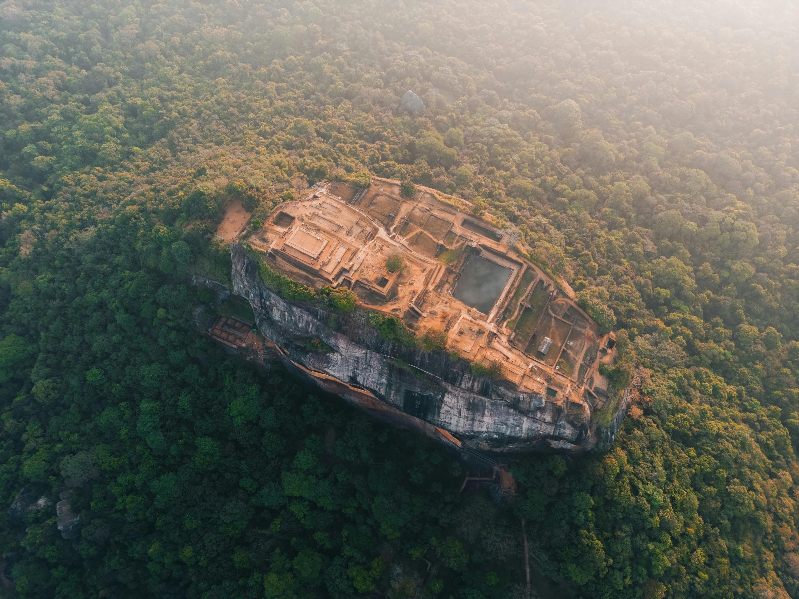 Sigiriya rock fortress — golden hour, climbers on the stair